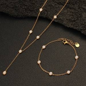 Detailed view of a gold stainless steel necklace and bracelet set with round zircons