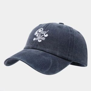 Close-up of Cool Mom white embroidery on vintage washed navy blue cotton baseball cap