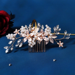 Golden bridal hair comb with pearls and crystals on a blue background with a red rose