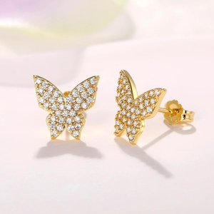Macro shot of gold butterfly earrings with pave-set clear cubic zirconia crystals