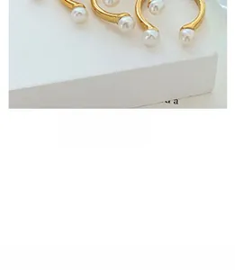 Detail shot of a French baroque gold titanium ring featuring white freshwater pearls