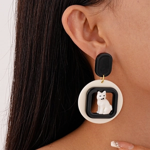 Close-up of a creative cartoon cat acrylic hoop earring worn on a model's ear