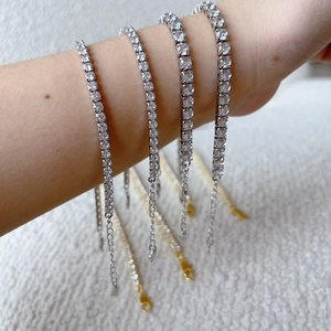 Close-up of four silver tennis bracelets with round zircons on a model's wrist