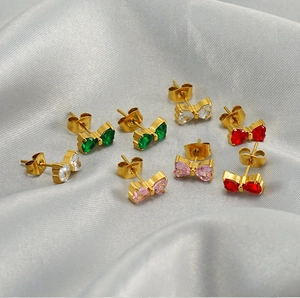 Detailed view of colorful heart-shaped crystal bow earrings in gold plating
