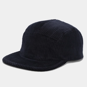 Detail view of navy blue corduroy fabric texture on a 5-panel camper style baseball hat