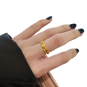 Minimalist wheat-patterned gold-plated ring with twisted textured design on model finger