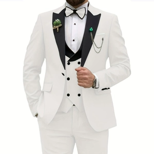 Detail of white wedding suit with black double-breasted vest and elegant green brooch