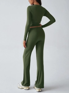 Rear view of dark green long sleeve crop top and flared yoga pants in soft knit fabric