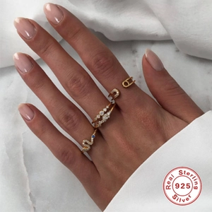 Detail of 925 sterling silver gold ring set with opal and diamond-studded serpent design