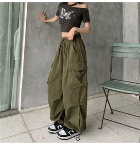 Detail of army green cargo pants featuring large side pockets and loose-fit silhouette