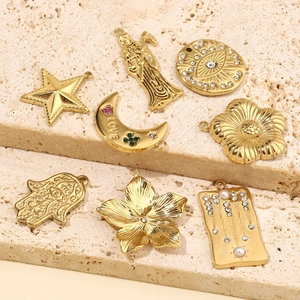 Detailed view of gold plated celestial pendants including moon, stars and evil eye charms