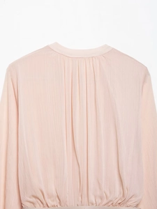 Detail of pink pleated chiffon midi dress showing fine vertical pleats and soft texture