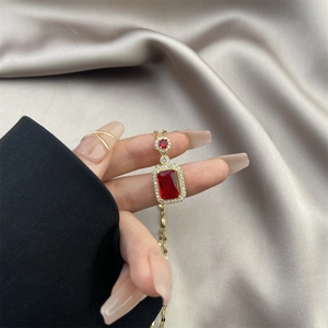 Détail du collier vintage doré avec pierre rouge rectangulaire et pavé de zircons