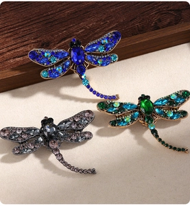 Detailed view of dragonfly brooches featuring colorful crystals and intricate alloy settings