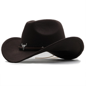 Détail d'un chapeau de cowboy en feutre marron avec emblème métallique de crâne de taureau