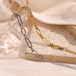 Close-up of gold and silver chain bracelet featuring mixed oval and round link design