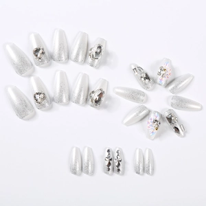 Macro detail of long coffin press-on nails with silver glitter, rhinestones and pearls