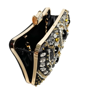 Close-up of golden metal frame and luxurious beaded detailing on the evening clutch bag
