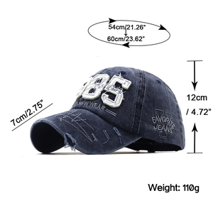 Detail der vintage dunkelblauen gewaschenen Denim-Baseballcap mit 1985 Stickerei und Löchern