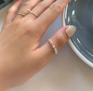 Close-up of a minimalist 925 sterling silver beaded ring worn on a woman's hand