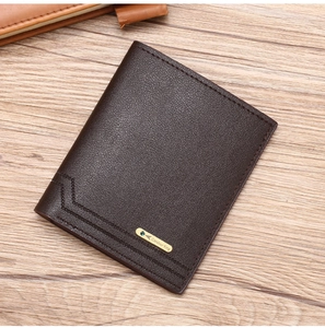 Close-up of brown textured leather wallet featuring a gold Candour King metal logo plate