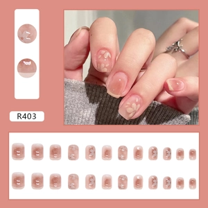 Short round press-on nails with pink gradient base and delicate white cherry blossoms