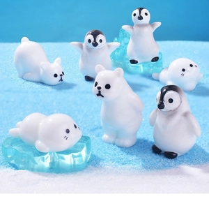Miniature polar animal figurines set with penguins and bears on artificial blue ice