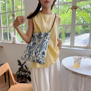 Detail of blue and white Toile de Jouy floral canvas bag with long thin shoulder strap