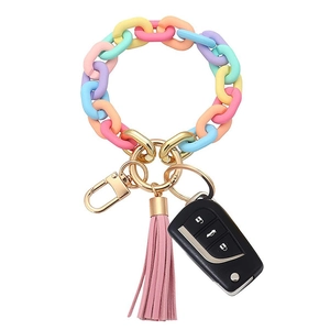 Detailed macro view of a macaron colored acrylic keychain with pink tassel and gold ring