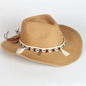 Detail of hand-woven straw cowboy hat with shells, tassels and bohemian braided trim