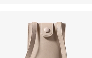 Detail of beige leather phone bag with snap closure and lychee grain texture