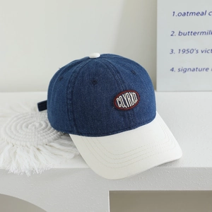 Detail of navy denim baseball cap with white brim and vintage CQYRXD embroidery