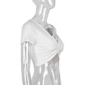 Dettaglio crop top bianco a costine con scollo a V e design intrecciato sul davanti