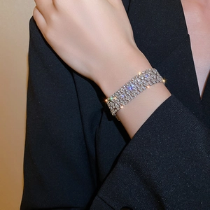 Close-up of wide multi-row sparkling rhinestone bracelet worn on a female wrist
