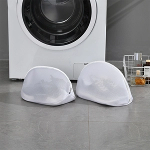 Thick mesh laundry bags for shoes in white, set of 2, placed near a washing machine