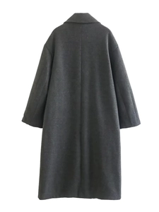 Detail view of the back of a charcoal grey wool coat with elegant oversized minimalist cut