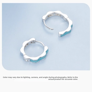 Detailed macro view of S925 sterling silver hoop earrings with blue enamel petal design