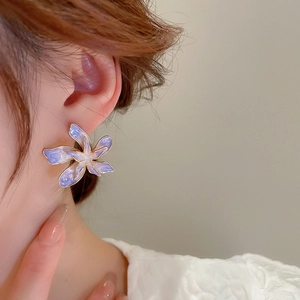 Gros plan de boucles d'oreilles fleurs mauves dégradées avec bordure dorée