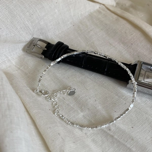 Close-up of crushed silver S925 beaded bracelet with lobster clasp and extension chain