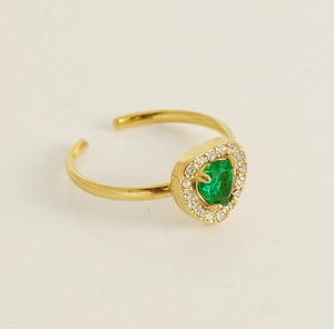 Close-up of 18K gold ring featuring a green heart-shaped gemstone with diamond halo