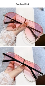 Détail de lunettes de soleil cœur sans monture avec verres dégradés roses et cadre doré