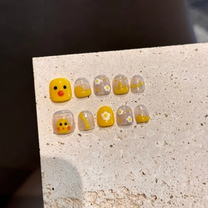 Handmade yellow duck press-on toenails set with floral patterns on stone display