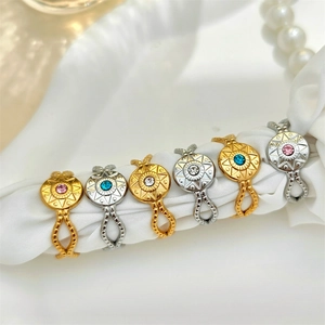 Vintage gold and silver starburst rings with colorful stones on white silk background