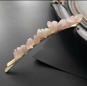Close-up of pink natural crystal stones set on a golden metal hair clip accessory