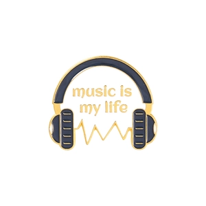 Détail d'une broche casque de musique émaillée noir et or avec gravure 'music is my life'