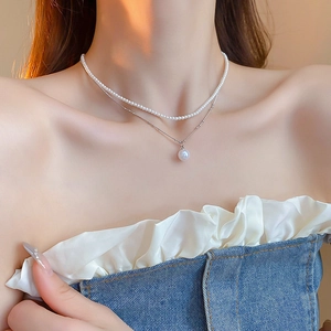 Gros plan d'un élégant collier de perles à double rangée sur le cou du mannequin