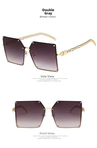 Detail of oversized square sunglasses with gold chain temples and grey gradient lenses
