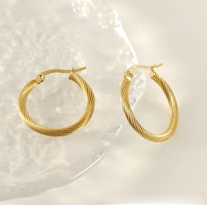 Detailed view of gold twisted hoop earrings showing the elegant spiral texture and finish