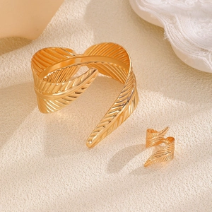 Macro detail of golden leaf-shaped open bracelet and ring set with fine textures