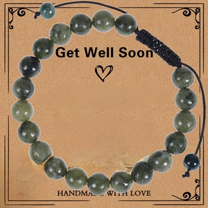 Detail of dark green natural stone beads and sunflower charm on a gift display card